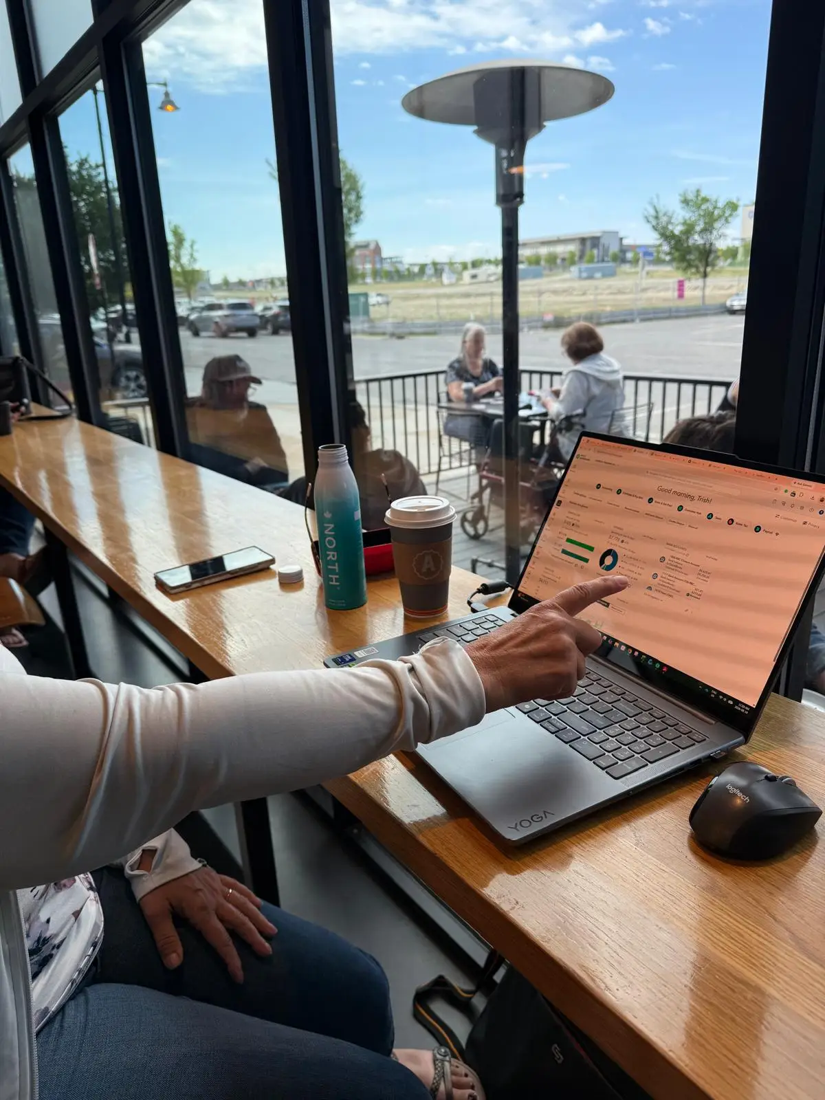 Trish working at her desk with a laptop and a notebook